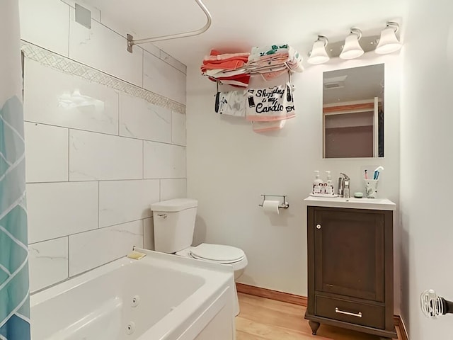 full bath featuring a combined bath / shower with jetted tub, vanity, toilet, and wood finished floors