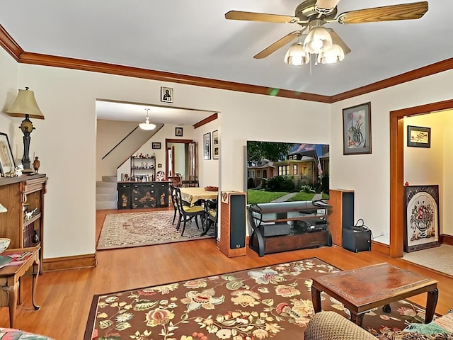 living room with ornamental molding, ceiling fan, stairway, and wood finished floors