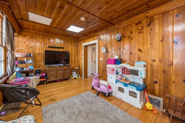 playroom featuring wooden ceiling, wood finished floors, visible vents, and wood walls