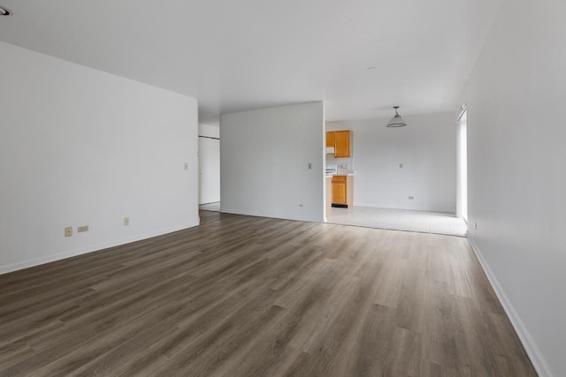 unfurnished living room with baseboards and wood finished floors