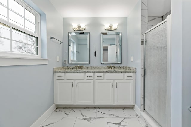 full bathroom with a stall shower, marble finish floor, a sink, and baseboards