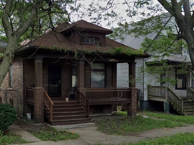 bungalow-style home featuring stairs, a porch, and brick siding