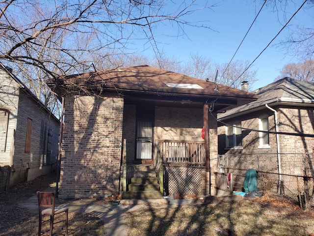 back of house featuring brick siding and covered porch