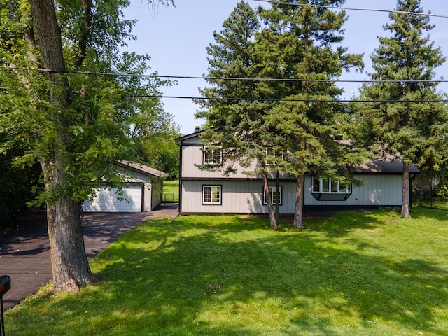 view of front facade featuring a front yard, an outdoor structure, and a detached garage