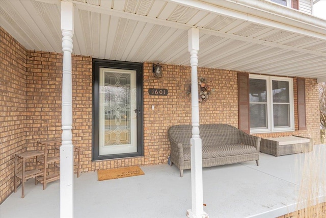 property entrance with brick siding and covered porch