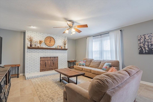 living room featuring baseboards, light tile patterned floors, a fireplace, a textured ceiling, and a ceiling fan