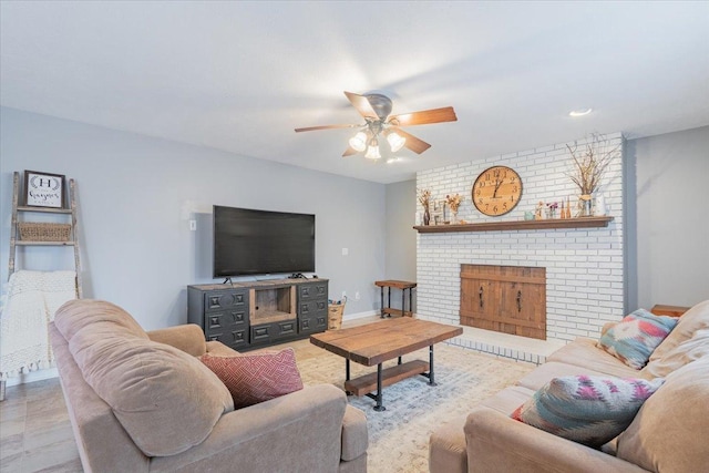 living area featuring baseboards, a fireplace, and a ceiling fan