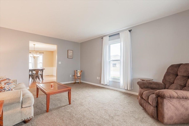 living area with a notable chandelier, baseboards, and carpet