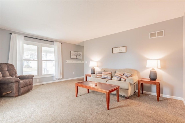 living room with baseboards, visible vents, and light carpet