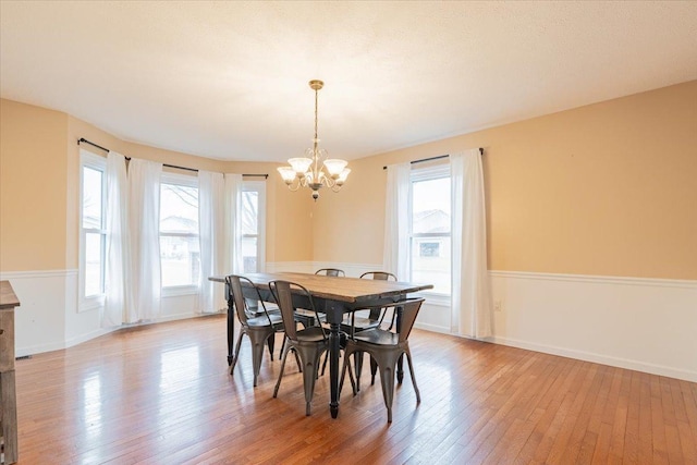 dining space with light wood-style floors, baseboards, and a chandelier