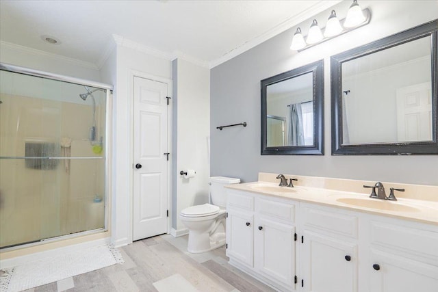 full bathroom with a sink, toilet, ornamental molding, and a shower stall