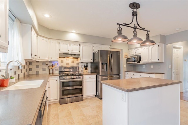 kitchen with a sink, stainless steel appliances, under cabinet range hood, white cabinetry, and tasteful backsplash