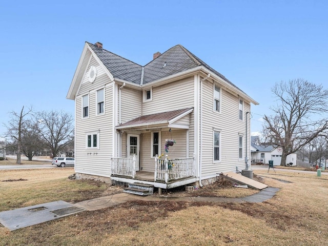 view of front of house with a front yard, covered porch, a chimney, and central AC unit