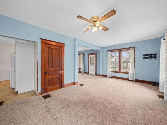 spare room featuring carpet floors, visible vents, and baseboards