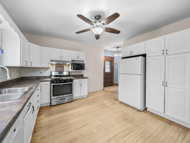 kitchen with under cabinet range hood, white appliances, a sink, white cabinets, and light wood finished floors