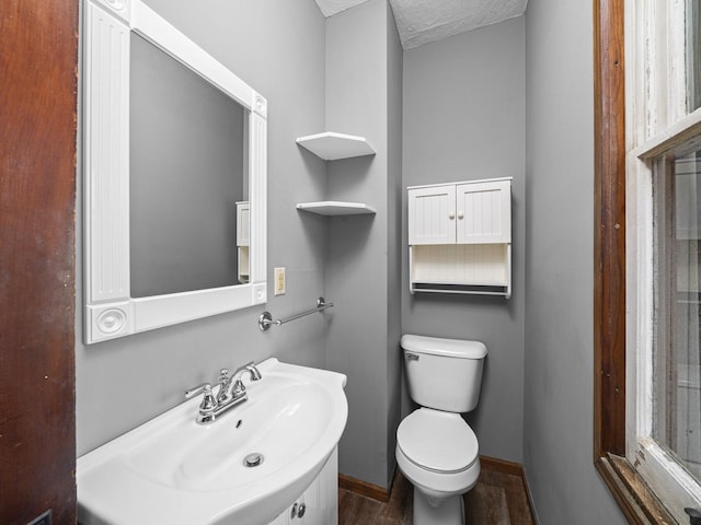 bathroom with baseboards, a sink, and toilet