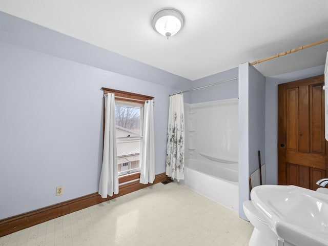 bathroom featuring shower / tub combo, a sink, baseboards, and tile patterned floors