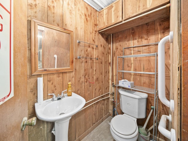 half bath with toilet and wooden walls