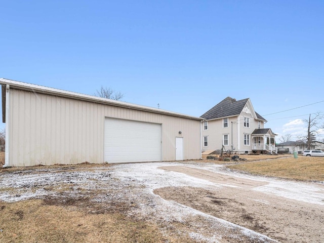 view of front of home with a detached garage and an outbuilding