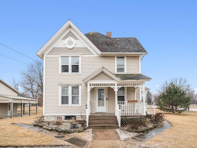 victorian-style house with a porch, a shingled roof, and a chimney