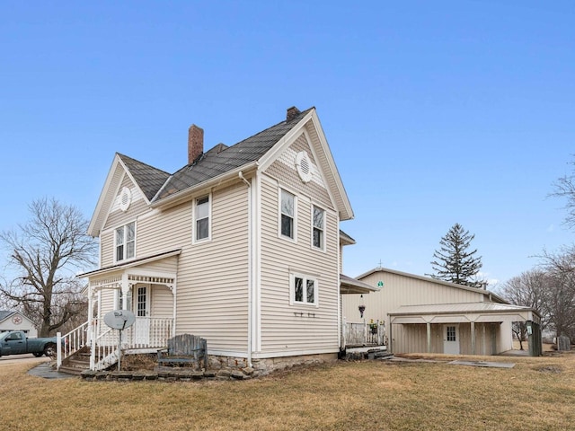 view of property exterior featuring a porch, a lawn, and a chimney