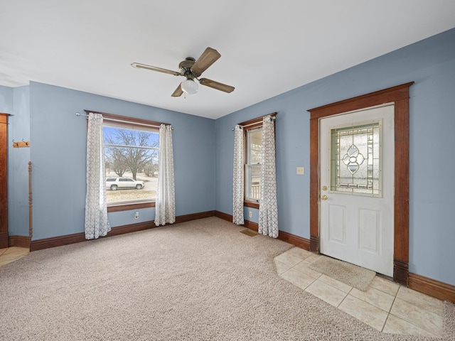 foyer with light carpet, a ceiling fan, and baseboards