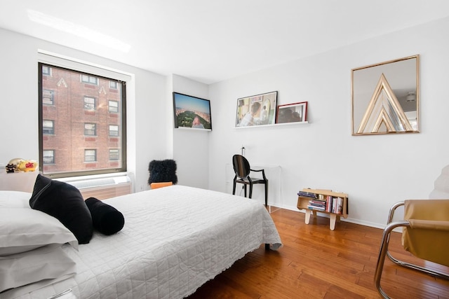 bedroom with baseboards and wood finished floors