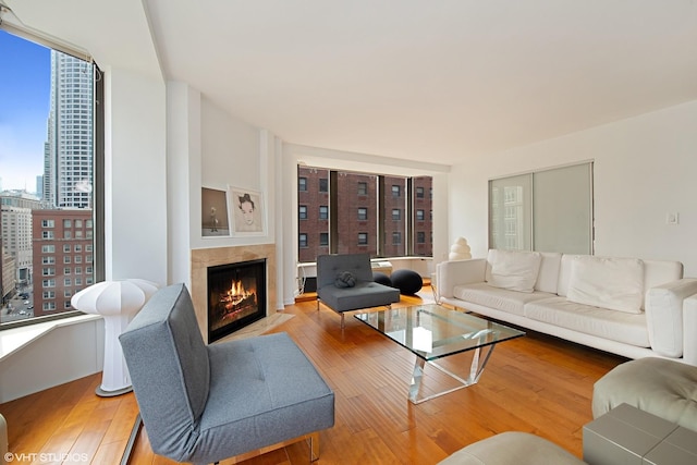 living area featuring light wood-type flooring, a fireplace with flush hearth, and a city view