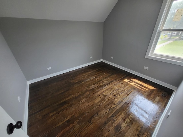 additional living space with lofted ceiling, baseboards, and dark wood-type flooring