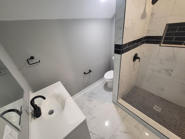 bathroom featuring toilet, vanity, baseboards, marble finish floor, and a tile shower