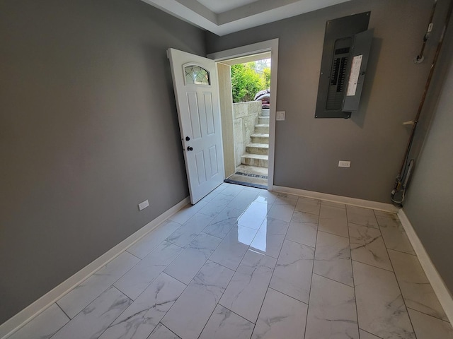 foyer entrance with marble finish floor, electric panel, baseboards, and stairs