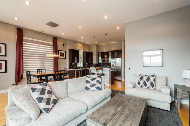 living room featuring recessed lighting, light wood-type flooring, and baseboards