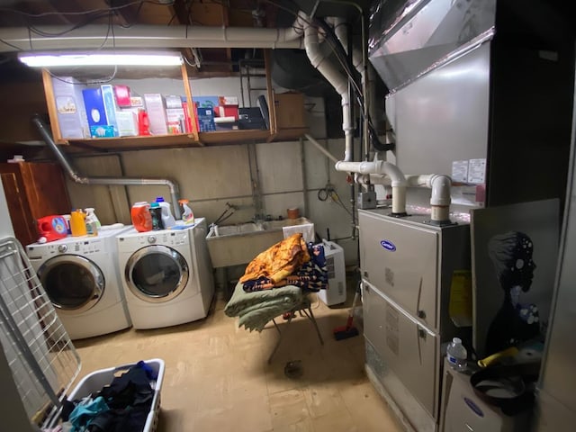 clothes washing area with laundry area, a sink, and separate washer and dryer