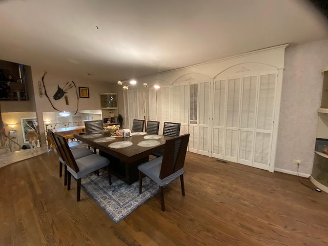 dining space with baseboards and wood finished floors