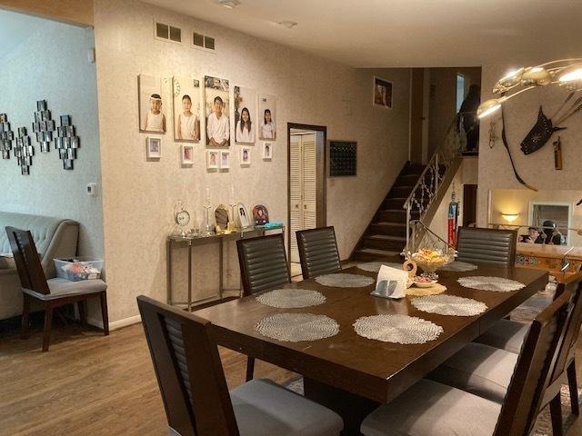 dining room with stairway, wood finished floors, and visible vents