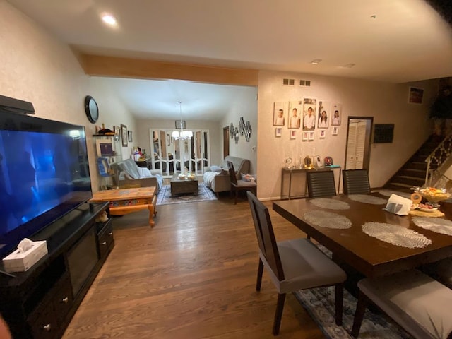 dining area with visible vents, stairs, a chandelier, and wood finished floors