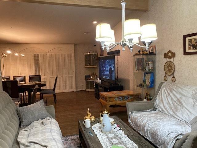 living area with a notable chandelier and wood finished floors