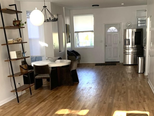 dining space with wood finished floors, baseboards, and a chandelier