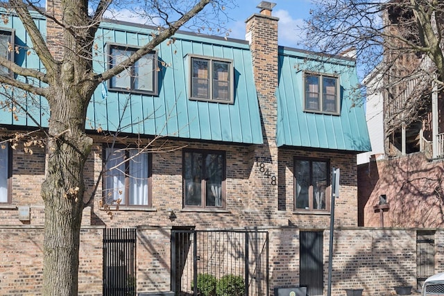 view of front of property featuring a fenced front yard and brick siding