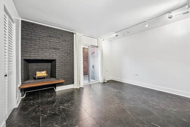 unfurnished living room with rail lighting, visible vents, baseboards, and a fireplace