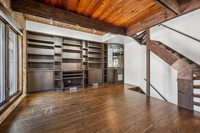 unfurnished living room with wood finished floors, beam ceiling, stairs, track lighting, and wooden ceiling