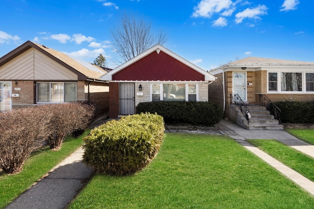 bungalow featuring a front lawn and brick siding