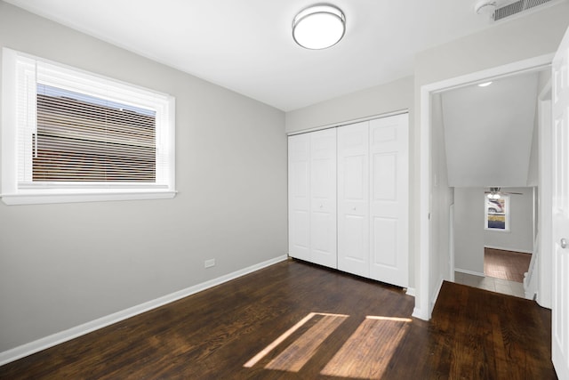 unfurnished bedroom with visible vents, baseboards, a closet, and wood finished floors