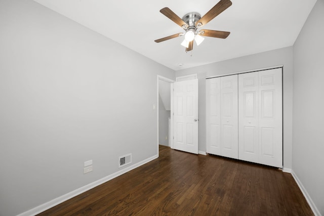 unfurnished bedroom featuring a ceiling fan, wood finished floors, visible vents, baseboards, and a closet