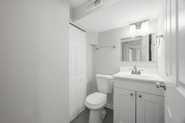 half bathroom with vanity, visible vents, tile patterned flooring, a closet, and toilet