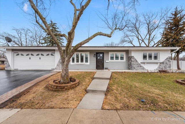 ranch-style house with a front lawn, stone siding, driveway, and an attached garage