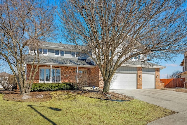 view of front of property featuring driveway, fence, a front yard, a garage, and brick siding