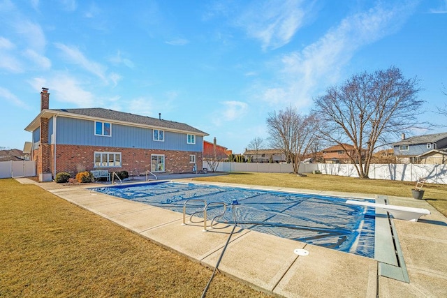 view of pool with a patio, a lawn, a diving board, and a fenced backyard