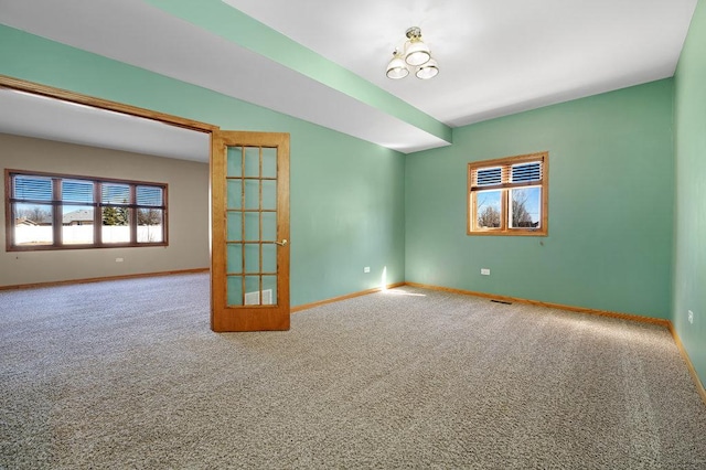 carpeted empty room with visible vents and baseboards