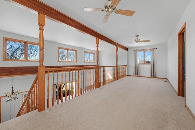 corridor with baseboards, beam ceiling, carpet, and visible vents